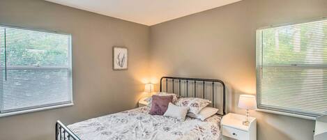 A bedroom with a bed, bedside tables, and a ceiling light.