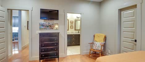 A bedroom with two beds, a dresser, a TV, and a chair.