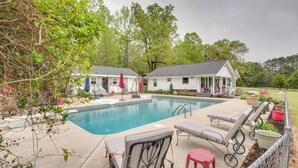 A pool area with lounge chairs, a red stool, and a covered patio. - Buckhead Cabin w/ Fireplaces & Private Pool! (Buckhead)