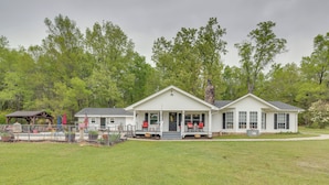 A two-story house with a front porch, a covered patio, and a fenced yard. - Buckhead Cabin w/ Fireplaces & Private Pool! (Buckhead)