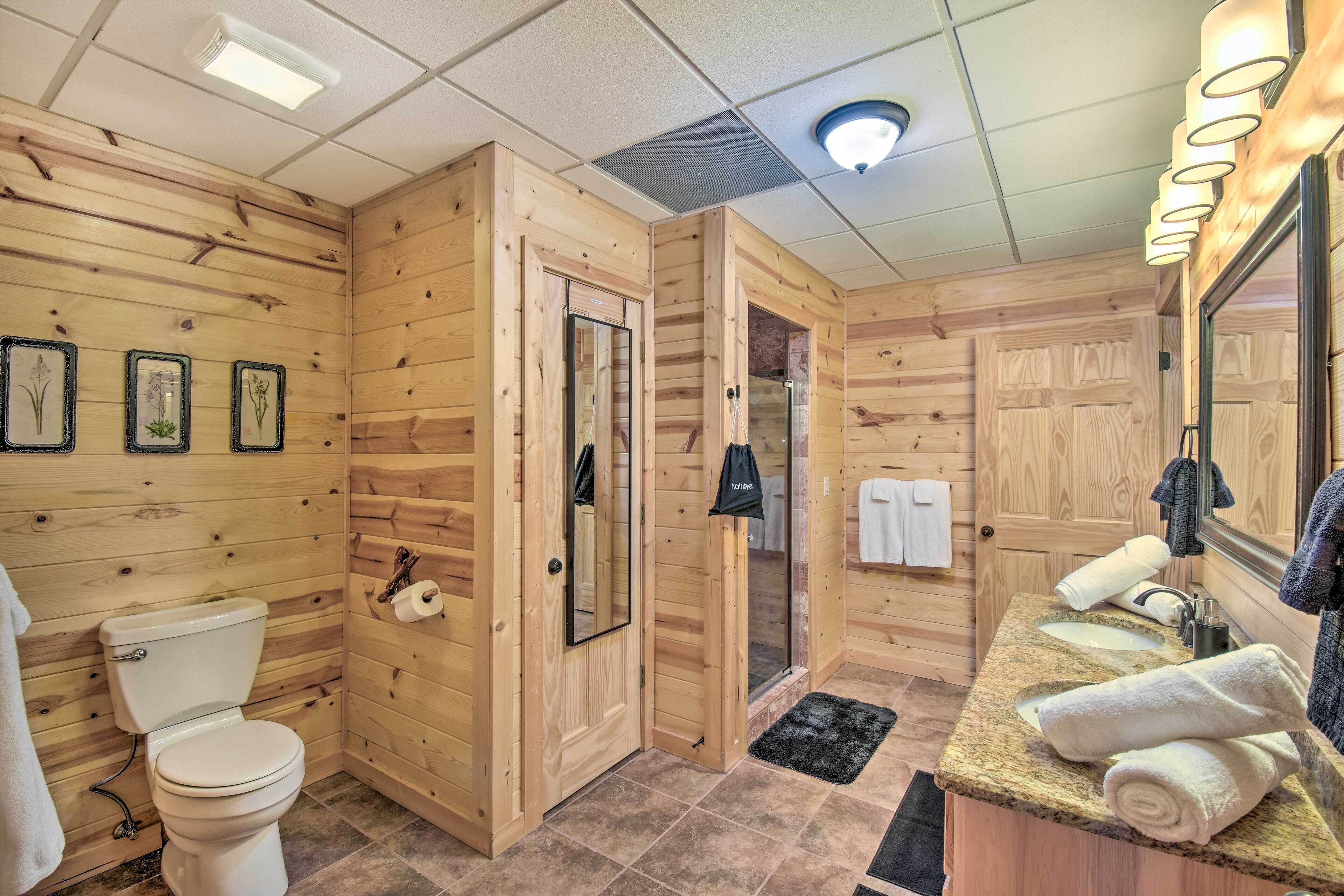 Ein Badezimmer im Holzblockhaus-Stil mit Toilette, Waschbecken und Spiegel.