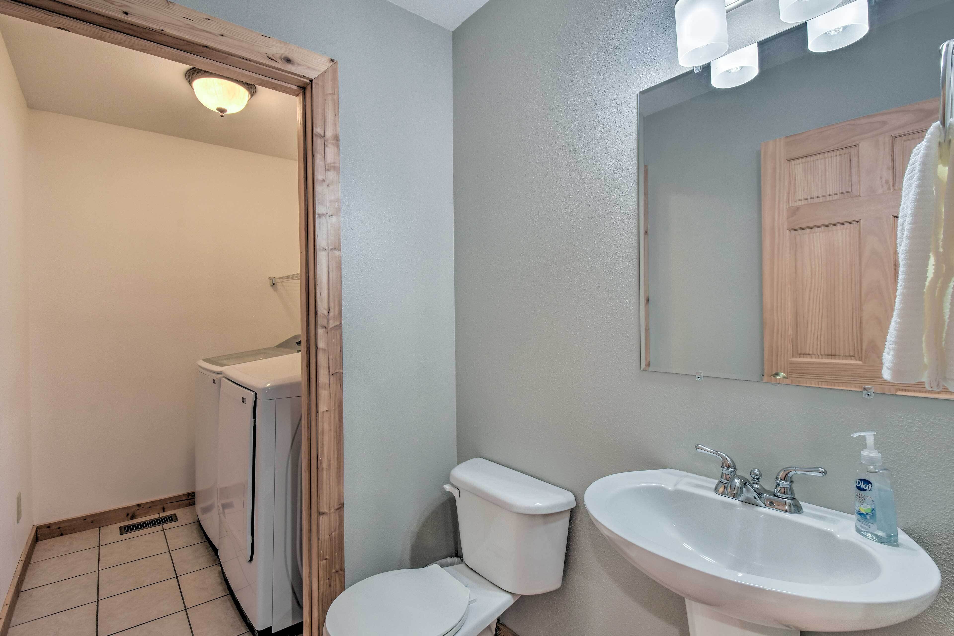 A bathroom with a toilet, sink, and mirror.