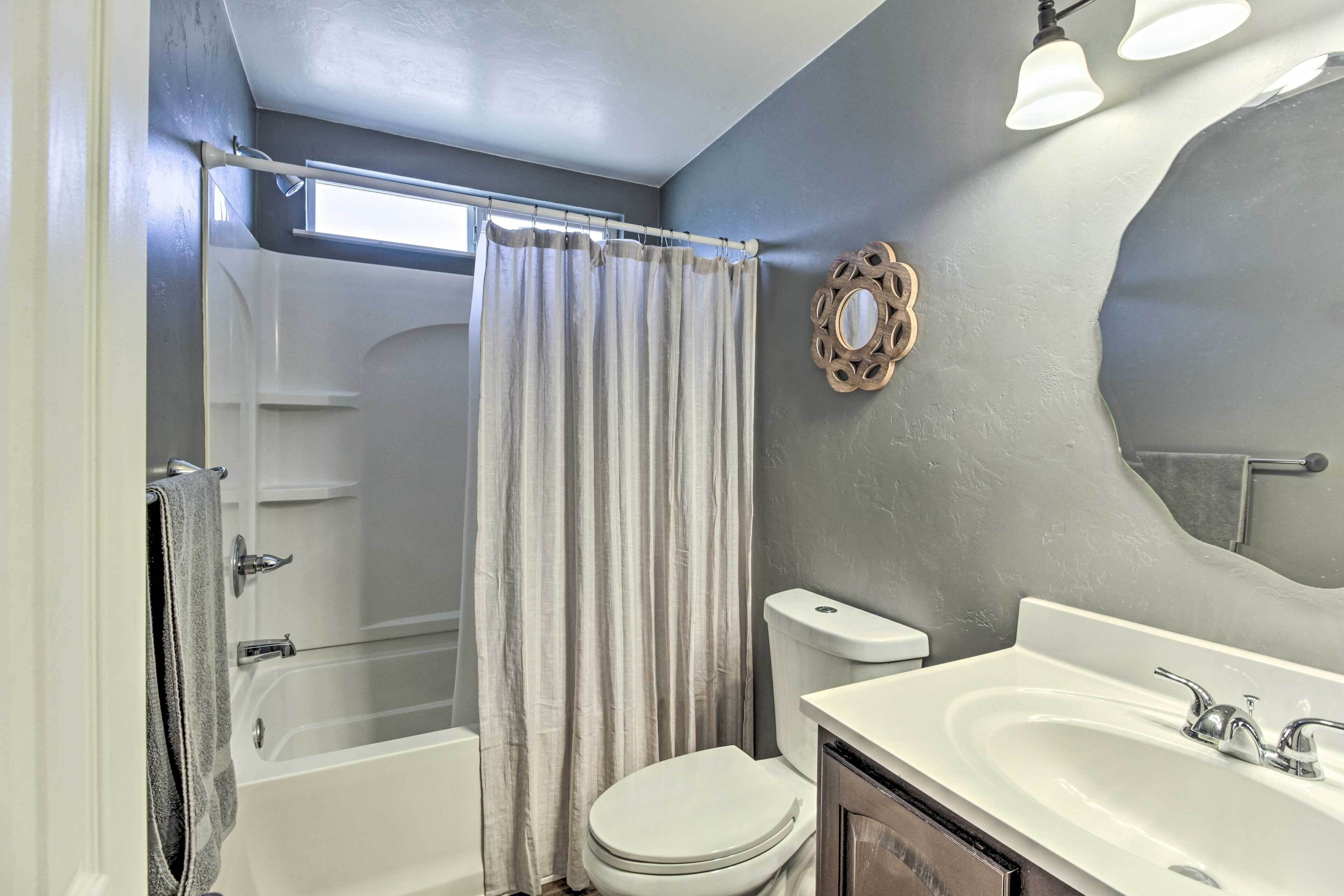 A bathroom with a bathtub, toilet, and sink.