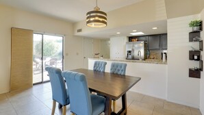 A modern kitchen with dark cabinets, a stainless steel refrigerator, and a granite countertop. - Sunny Tucson Townhome w/ Patio & Mountain Views! (Tucson)