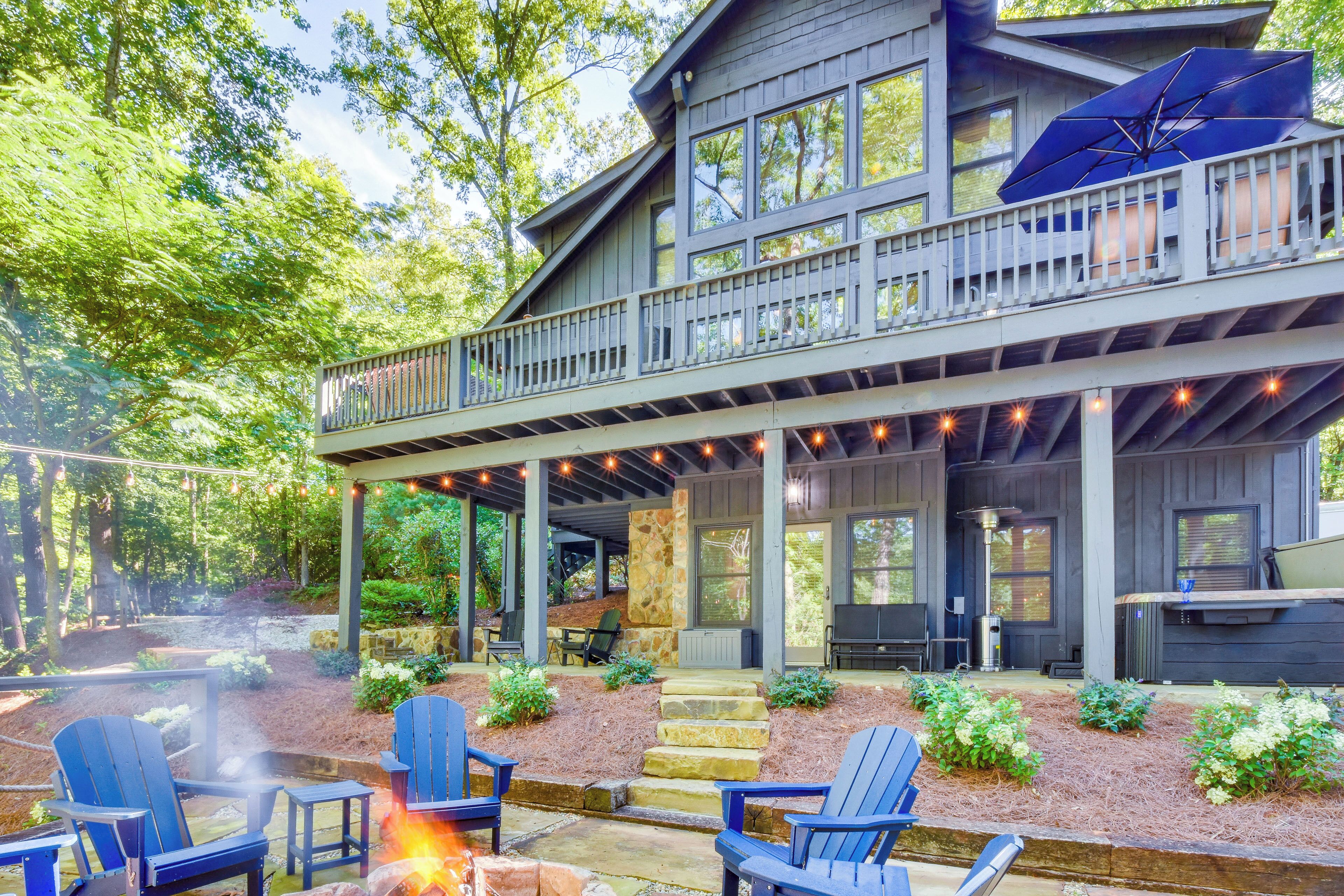 A two-story house with a covered patio, outdoor seating, and a fire pit.