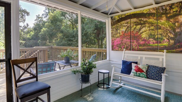 A covered porch with a wooden bench, a chair, and a potted plant. - Charming Thomasville Getaway: Walk to Downtown! (Thomasville)