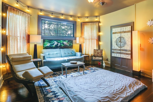 A cozy living room with a sofa, armchairs, a coffee table, and a large decorative rug.
