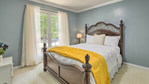 A bedroom with a large bed, a window with curtains, and a nightstand with a lamp. - Peaceful Dallas Home w/ Deck + Charcoal Grill (Dallas)