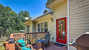 A deck with outdoor furniture, a barbecue grill, and a red door. - Peaceful Dallas Home w/ Deck + Charcoal Grill (Dallas)