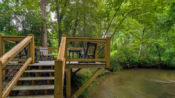 A wooden staircase leading to a platform with chairs overlooking a river. - 'drifting Feather' Mountain Cabin: Waterfront Deck (Blue Ridge)