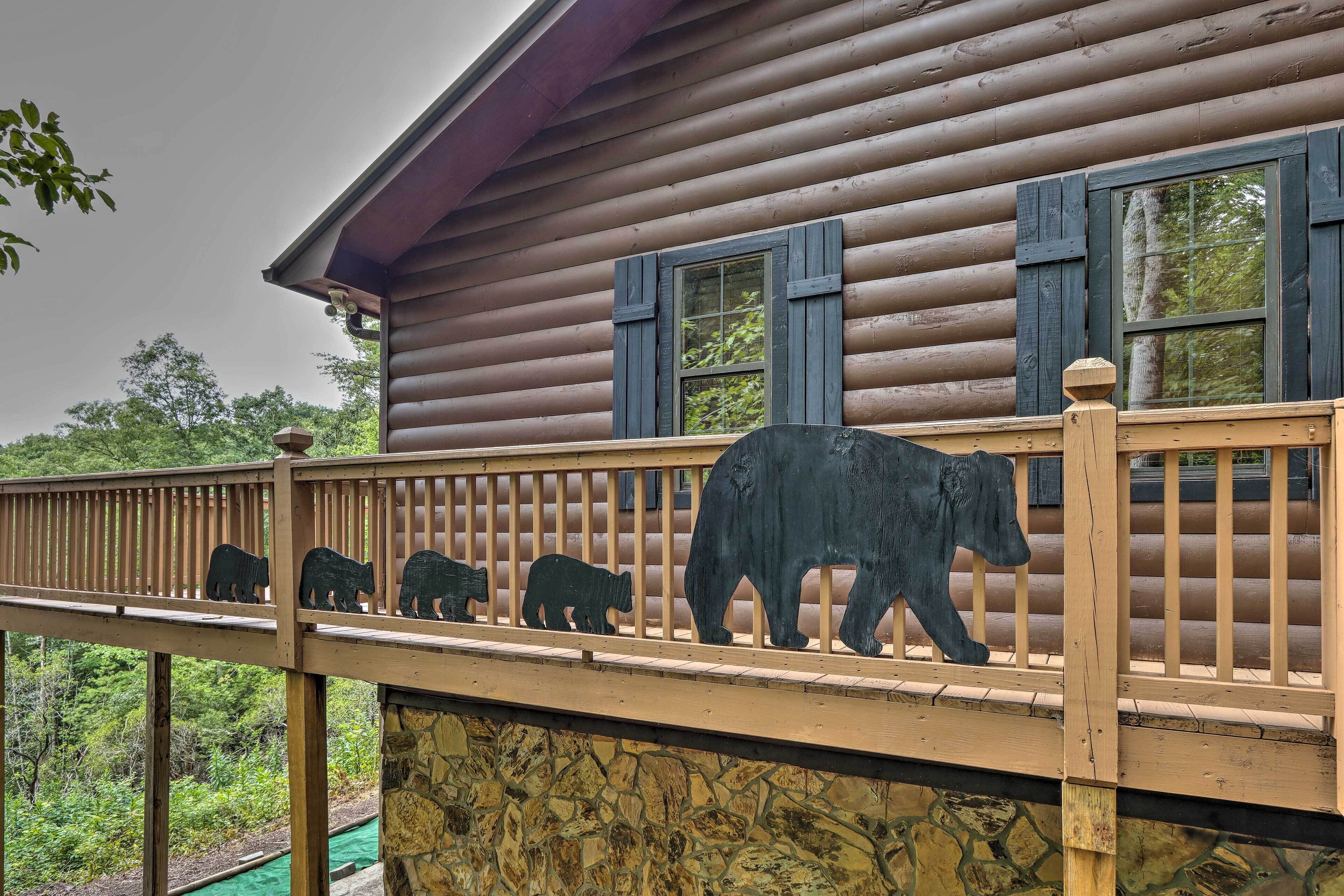 A wooden cabin with a balcony featuring bear cutouts.