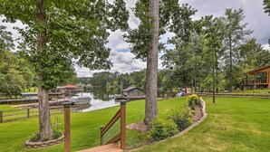 A lakeside property with a wooden deck, a boat dock, and a gazebo. - Lakeside Living: Sparta Retreat w/ Game Room! (Milledgeville)