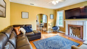 A living room with a sectional sofa, a fireplace, and a television. - Georgia Vacation Rental: 3 Mi to Downtown Columbus (Columbus)