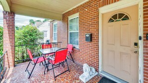 A covered patio with a brick wall, a beige door, and a small statue. - Georgia Vacation Rental: 3 Mi to Downtown Columbus (Columbus)
