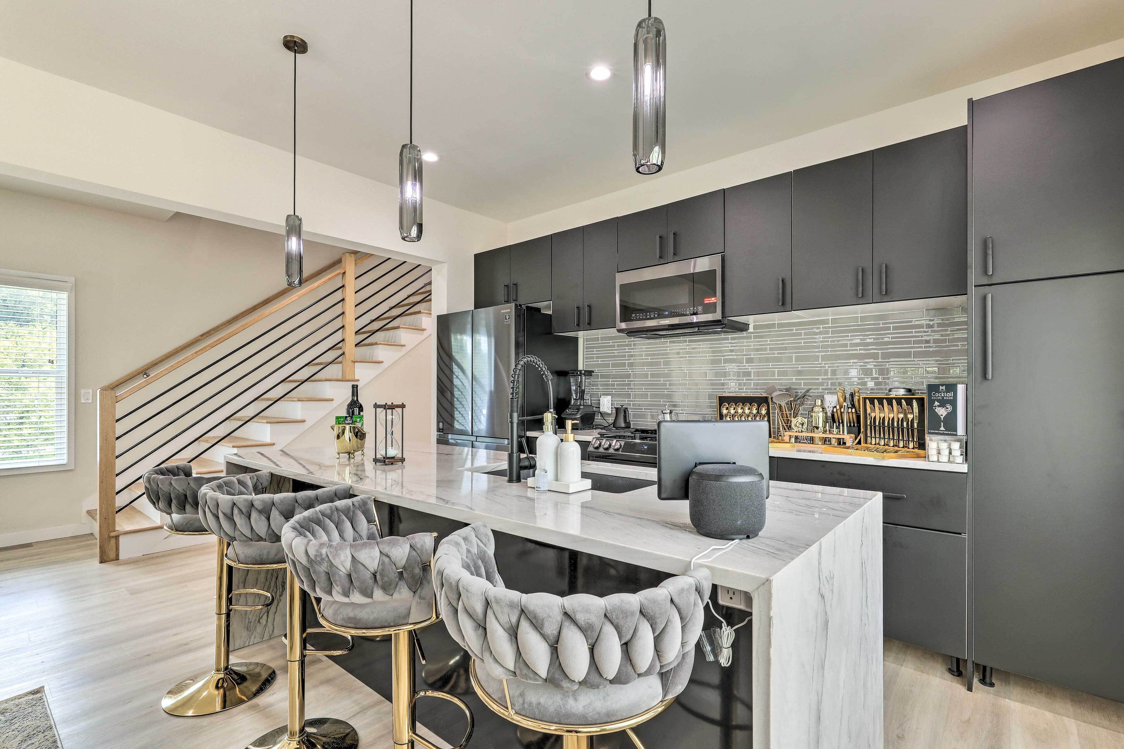 A modern kitchen with a marble island, stainless steel appliances, and a built-in wine cooler.