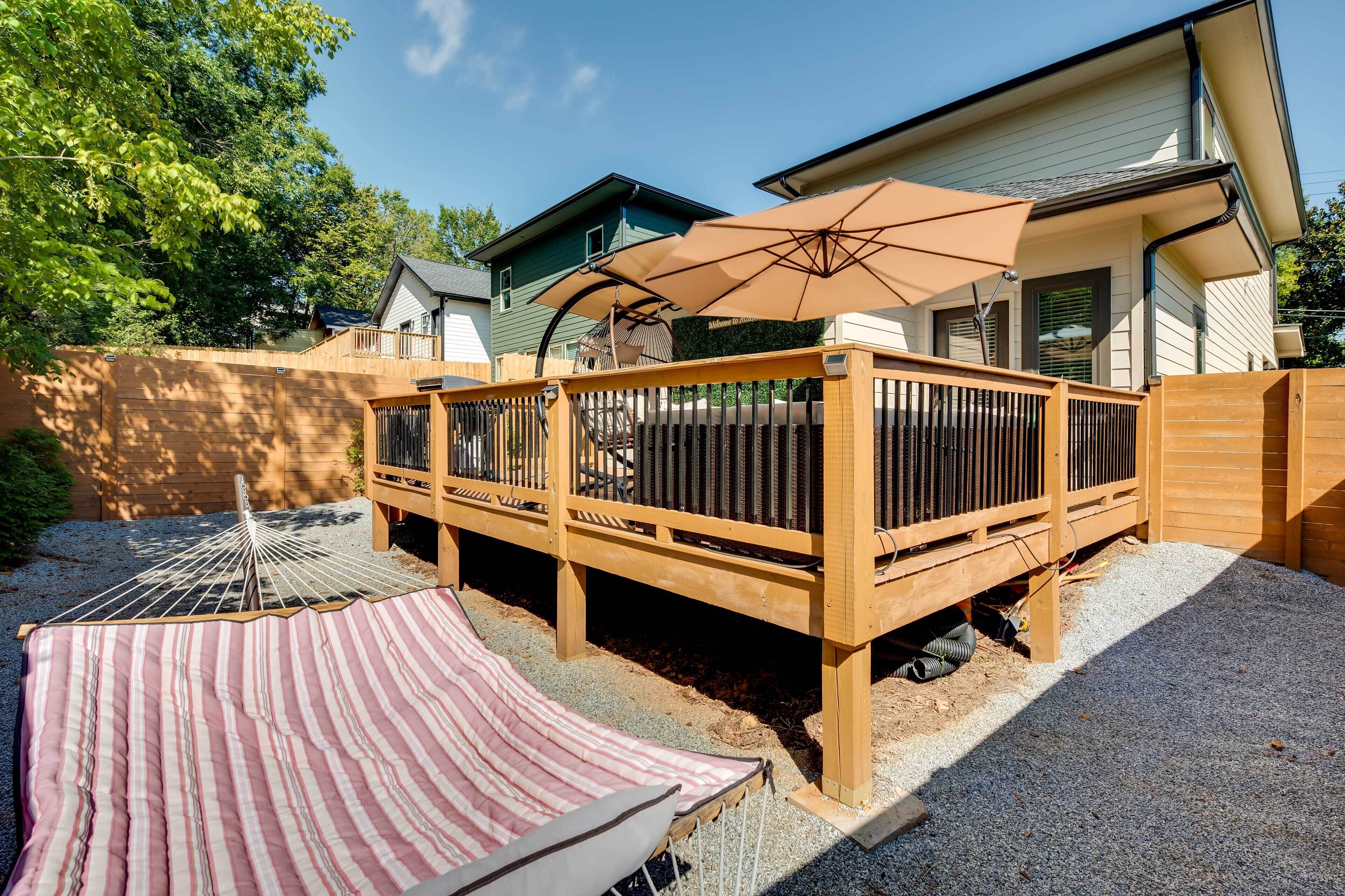 A wooden deck with a striped canopy and a large umbrella.