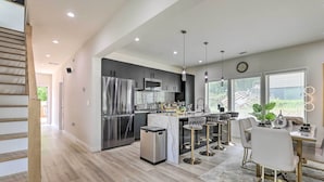 A modern kitchen with stainless steel appliances, a marble island, and pendant lighting. - Luxury Smart Home: 2 Mi to Downtown Atlanta! (Atlanta)