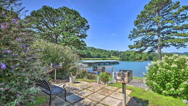 A lakeside patio with a bench, a grill, and a dock extending into the water. - Hiawassee Haven on Lake Chatuge w/ Boat Slip! (Hiawassee)