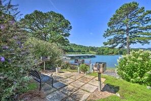 A lakeside patio with a bench, a grill, and a dock extending into the water. - Hiawassee Haven on Lake Chatuge w/ Boat Slip! (Hiawassee)