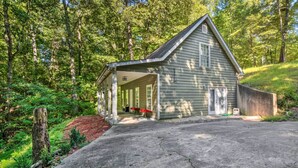 Un petit bâtiment en bois d’un seul étage, doté d’un porche et entouré d’une zone boisée.