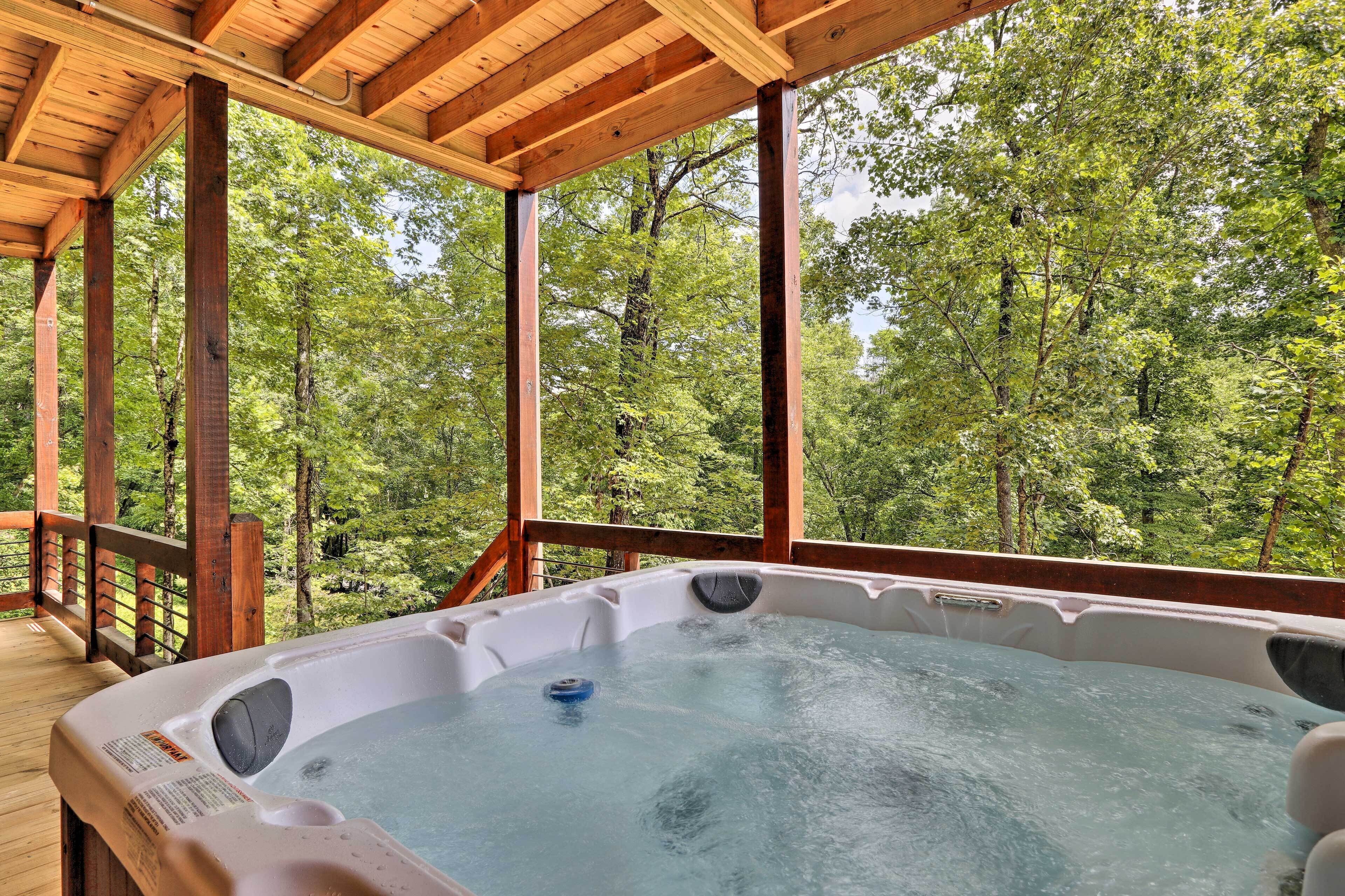 A hot tub in a wooden deck with a forest view.