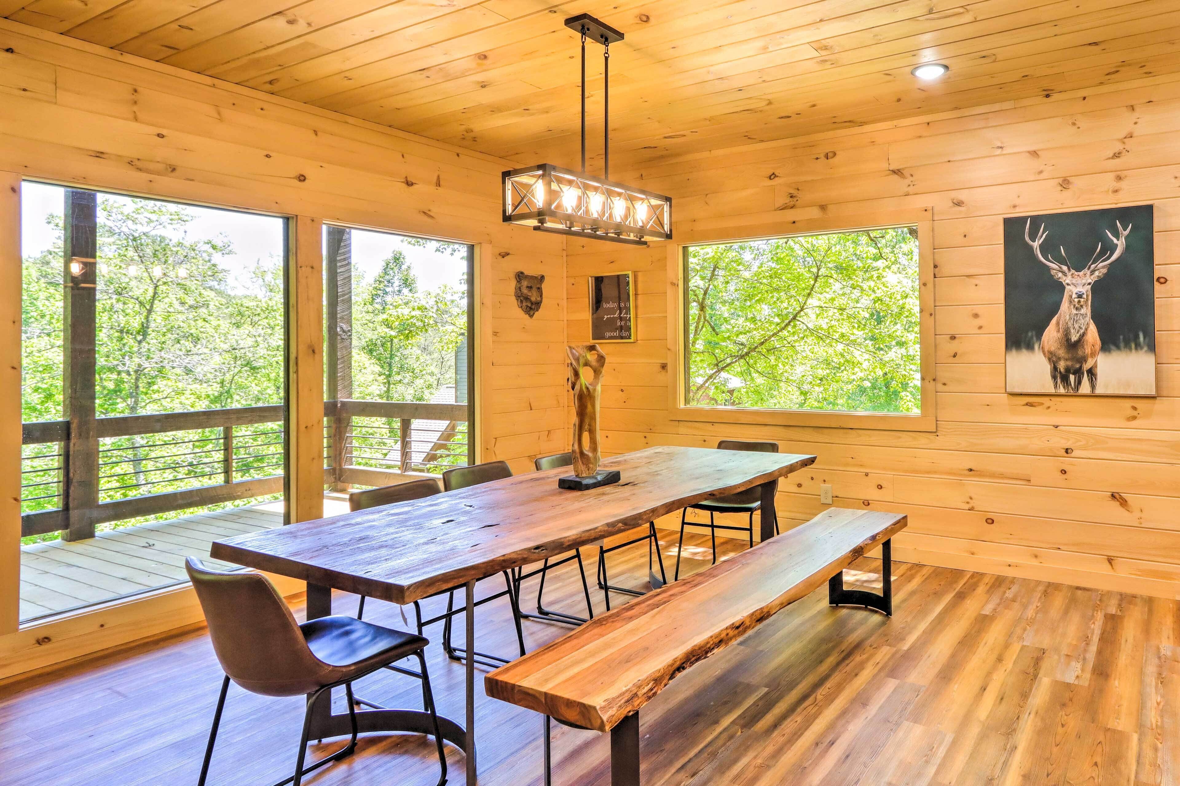 A wooden interior with a large dining table, benches, and chairs.