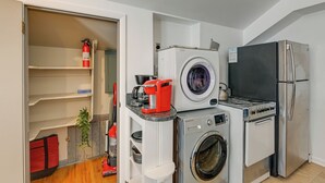 A compact laundry room with a washing machine, dryer, and a coffee maker on the countertop.