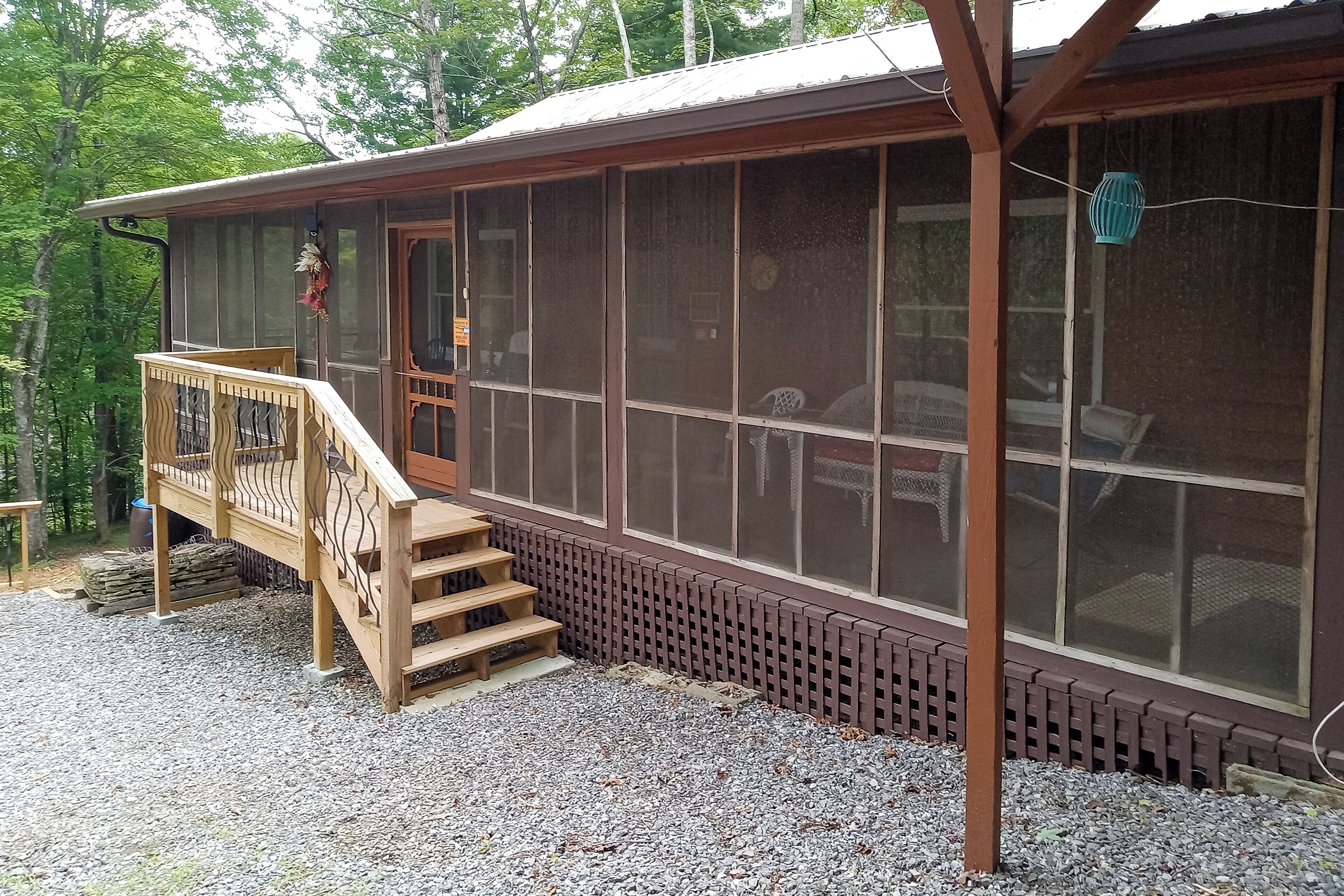 Een chalet met een houten terras, een overdekte veranda en een muur met horloge.