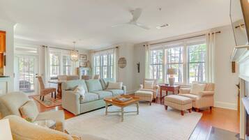A spacious living room with a large sofa, armchairs, a coffee table, and a fireplace.