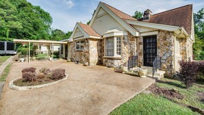 A stone house with a covered porch and a gravel driveway. - Cozy Jackson Vacation Rental < 1 Mi to University (Jackson)