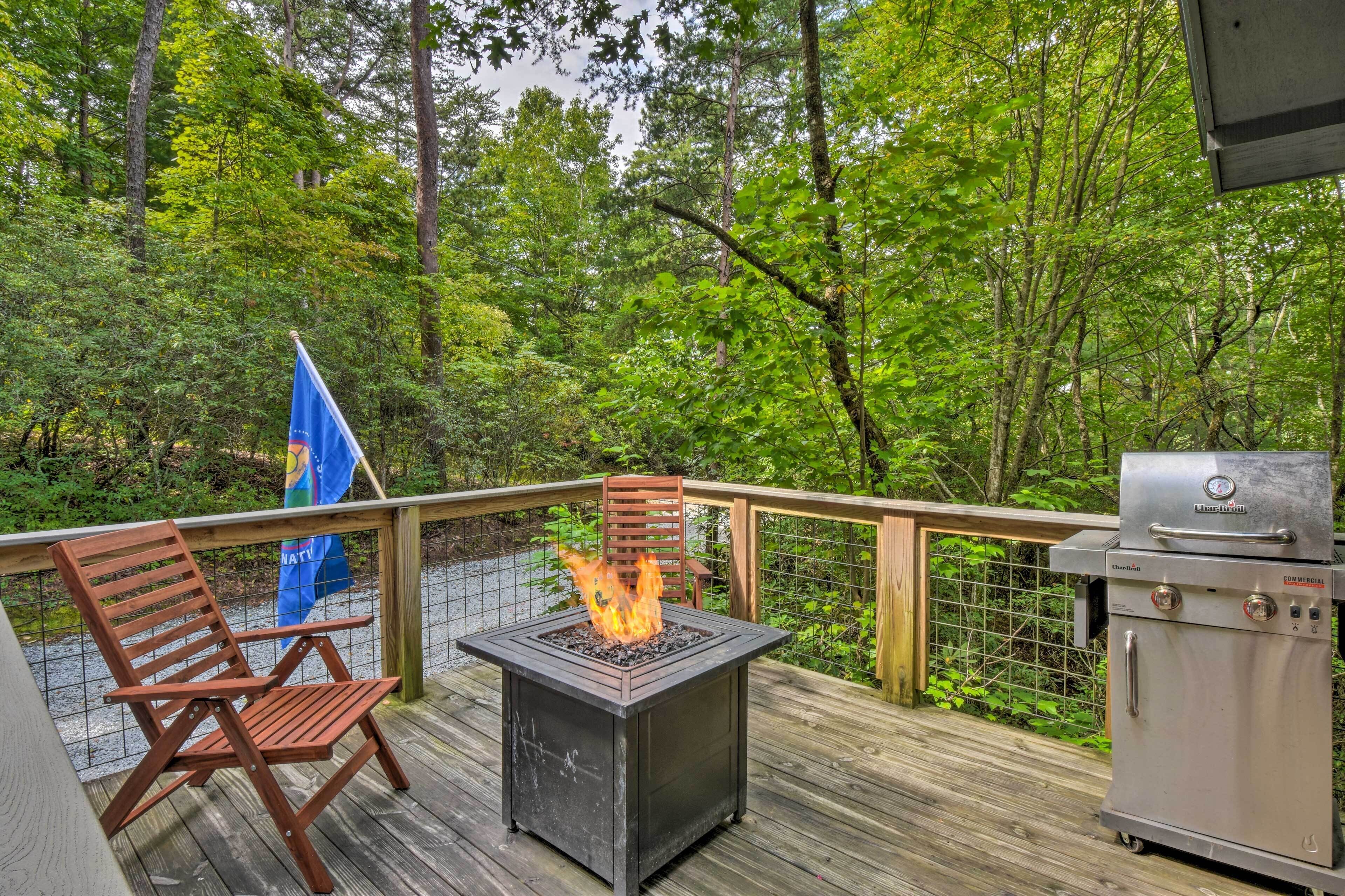 A deck with a fire pit, a grill, and a flag.