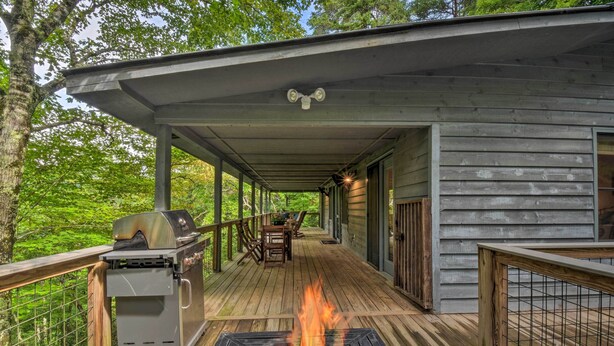 Eine überdachte Terrasse im Freien mit Grill und Feuerstelle.