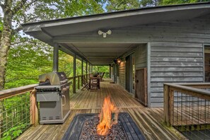 A covered outdoor deck with a grill and a fire pit. - Cozy Clayton Cabin w/ Deck & Mountain Views! (Clayton)