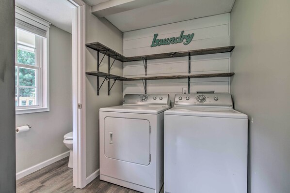 A laundry room with two stacked washers and dryers, a window, and a shelf labeled "Laundry".