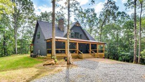 A cabin with a porch, surrounded by trees. - Luxurious Clarkesville Cabin w/ Decks & Fire Pit (Clarkesville)