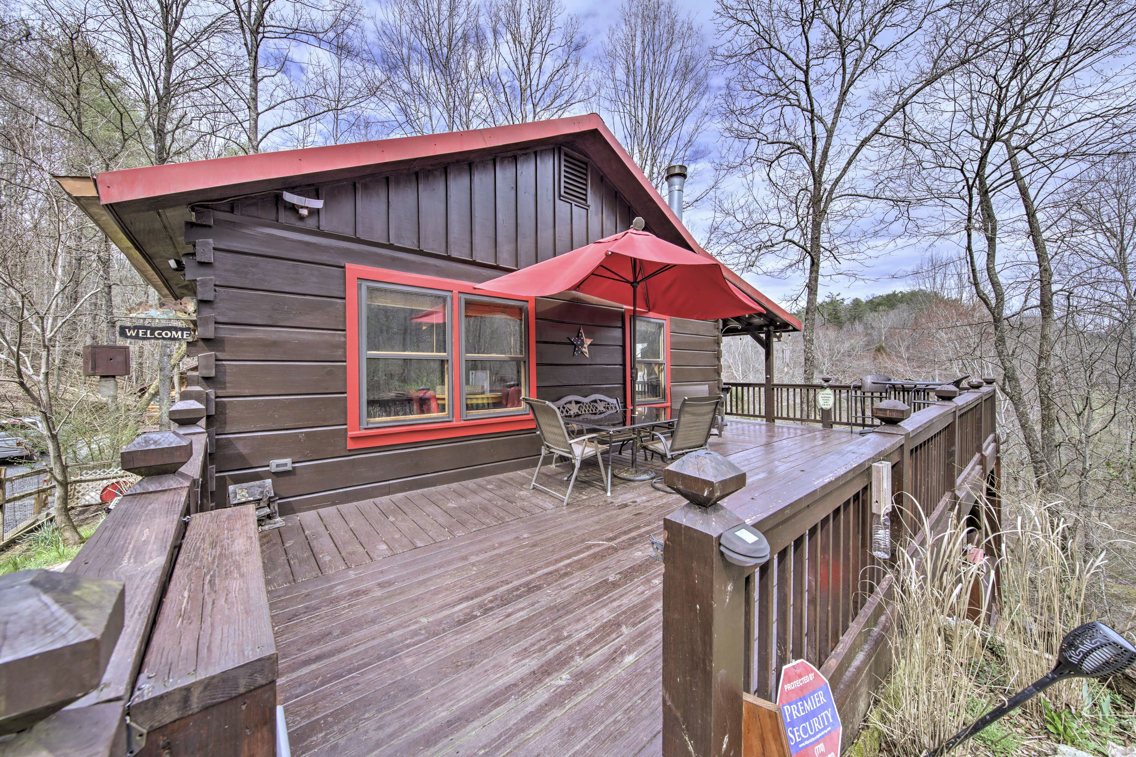 A wooden deck with outdoor seating and a red awning.