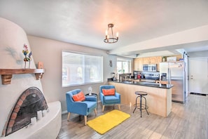 A modern kitchen with a central island, built-in appliances, and a fireplace. - Vibrant, Colorful Tucson Abode w/ Pool & Hot Tub (Tucson)