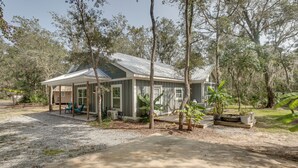 A single-story house with a covered porch, a small deck, and a gravel driveway. - Charming Darien Hideaway w/ Porch, Near Downtown! (Darien)