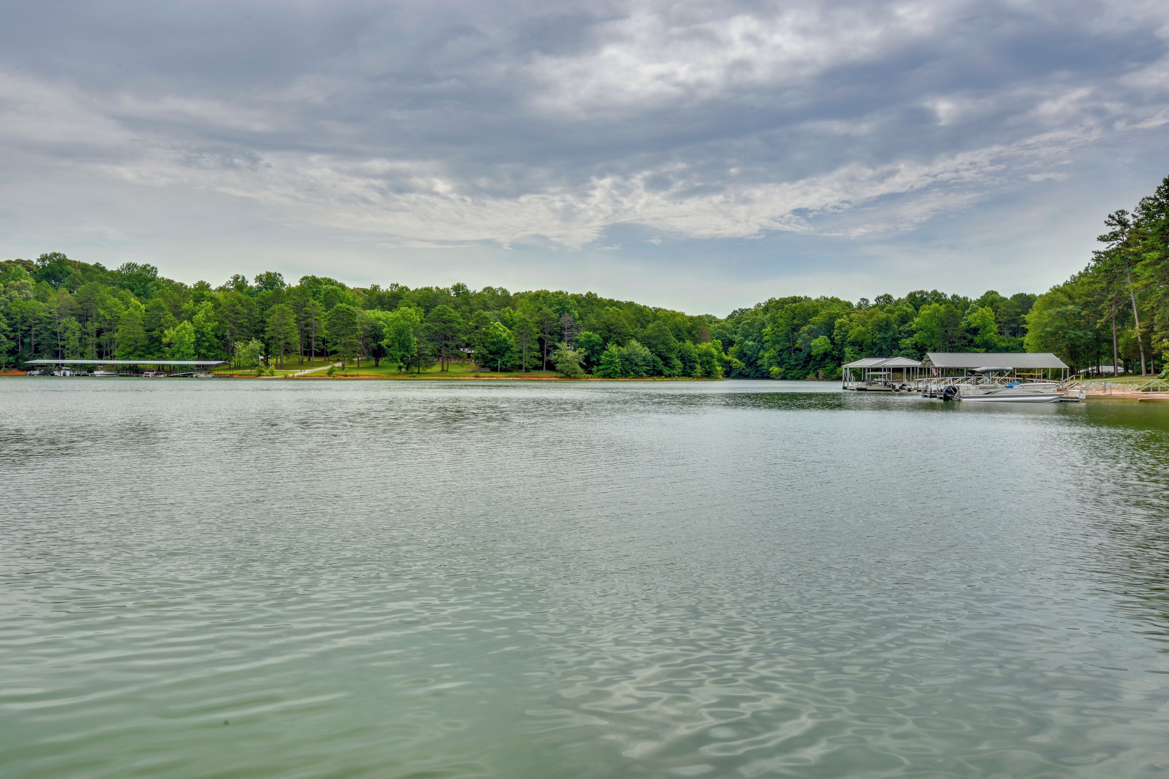 A lake with a dock and a building with a covered area.
