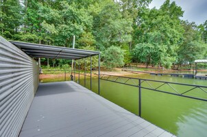Un espacio con cubierta y vista a una masa de agua verde y árboles circundantes.
