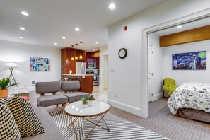 A modern living room with a sofa, armchairs, a coffee table, and a dining area with a kitchen in the background. - Near Lumen Field! Walkable Dtwn Seattle Condo (Seattle)