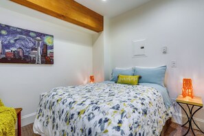 A bedroom with a bed, a painting, a nightstand, and a lamp. - Near Lumen Field! Walkable Dtwn Seattle Condo (Seattle)