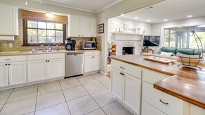 A modern kitchen with white cabinets, a microwave, and a dishwasher. There is a window with blinds, a sink, and a countertop with a basket. - Dock & Views! Waterfront Baisden's Bluff Home (Crescent)