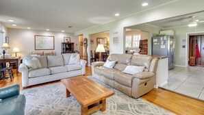 A spacious living room with two sofas, a coffee table, and a dining area with chairs. - Dock & Views! Waterfront Baisden's Bluff Home (Crescent)