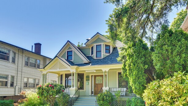 A two-story house with a front porch, a chimney, and a well-maintained garden. - Historical Portland Home < 2 Mi to Downtown! (Portland)