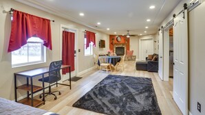 A spacious room with a desk, chair, and a dining area with a table and chairs. There is a fireplace and a sliding door closet. - Convenient Cedar City Studio < Half-mi to Downtown (Cedar City)
