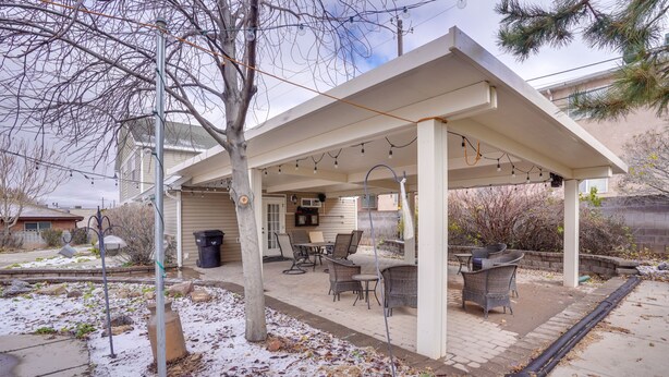 A covered patio with outdoor furniture, a grill, and string lights. - Convenient Cedar City Studio < Half-mi to Downtown (Cedar City)