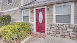 A house with a red door, stone foundation, and a small front yard with a bush. - Convenient Cedar City Studio < Half-mi to Downtown (Cedar City)