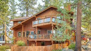 A multi-story wooden cabin with a balcony, surrounded by trees and a wooden fence. - Deck & Beach Access: Lake Tahoe Shoreside Retreat! (Zephyr Cove)
