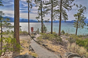 A natural landscape with a lake, mountains, and a clear sky.